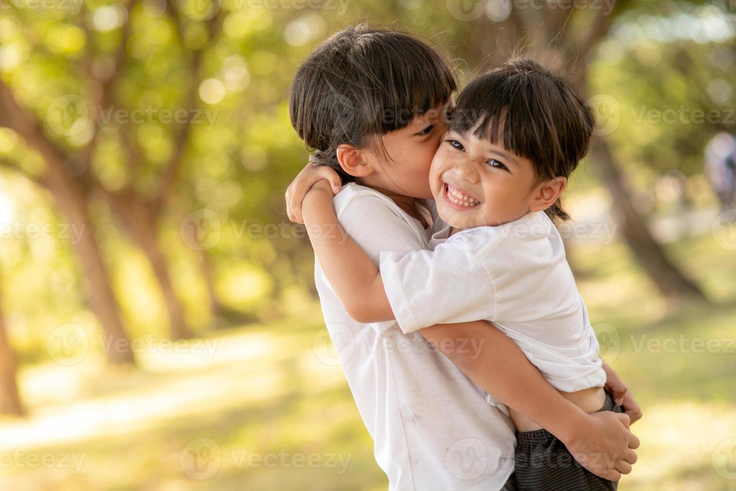 Two Asian little child girls hugging each other with love in the garden photo