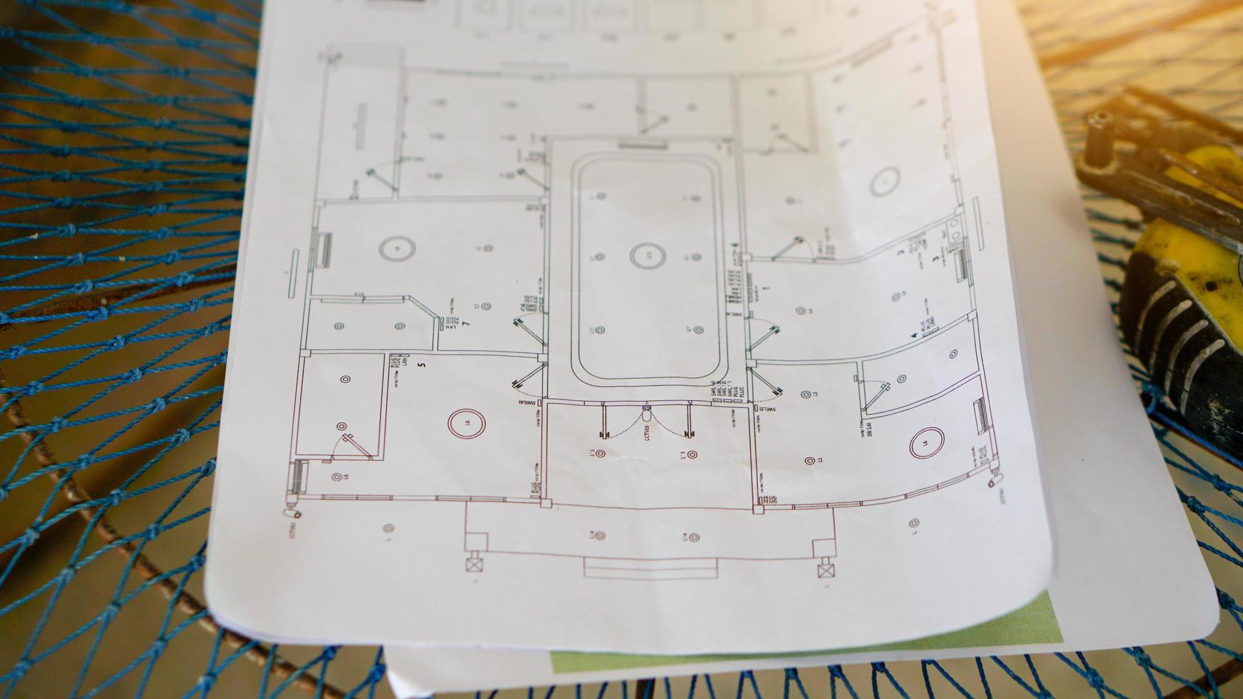 Abstract and construction background of house plan paper laid on the net. and there are blurry tools placed on the side. photo