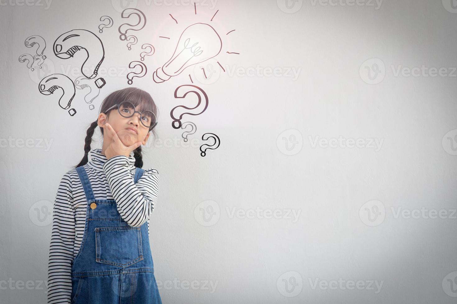 Happy asian school kid thinking photo