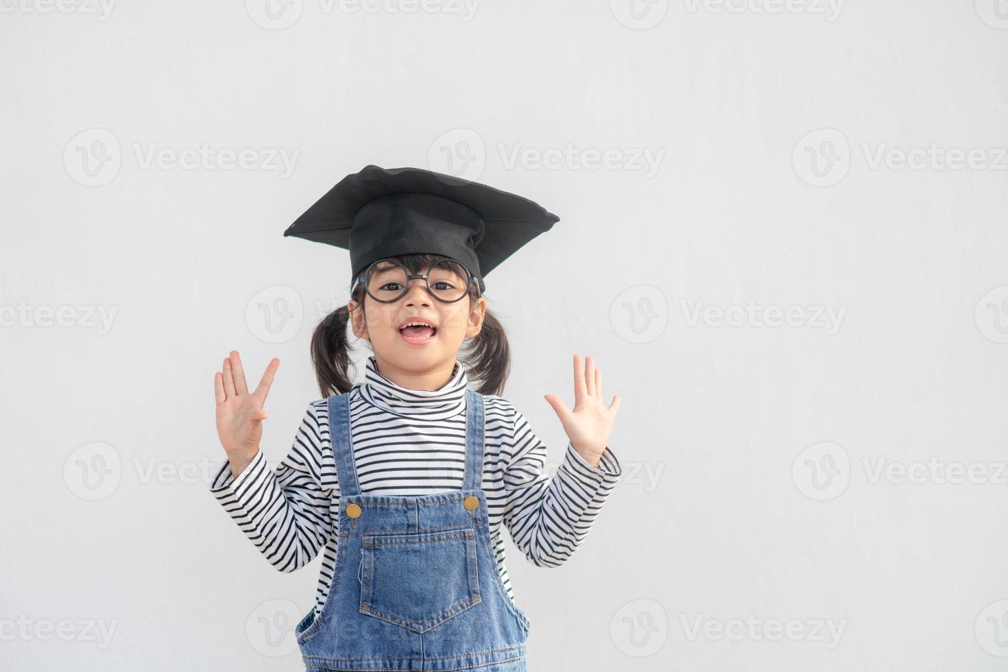 Happy Asian school kid graduate with graduation cap photo