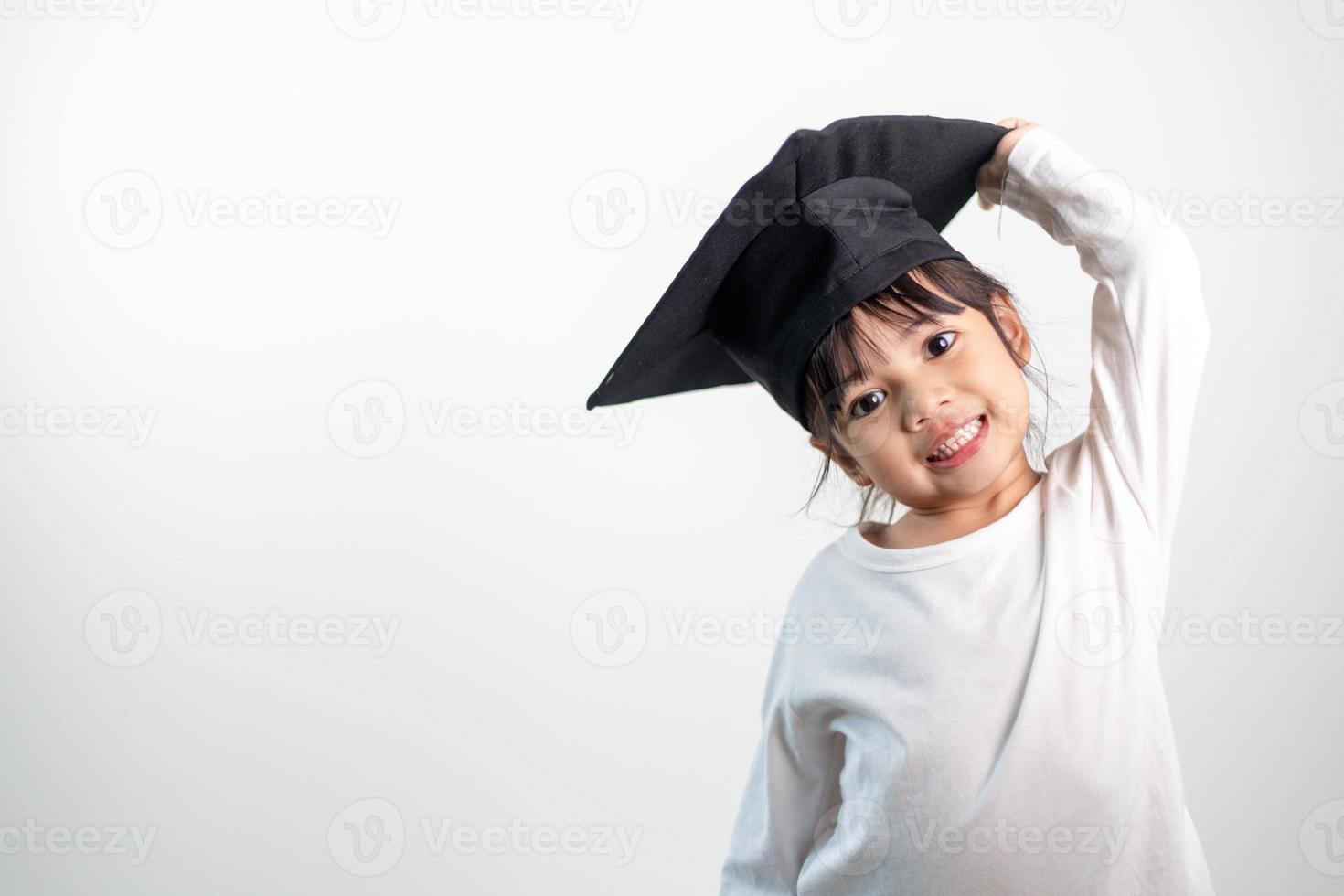 feliz niño de la escuela asiática graduado en gorra de graduación foto