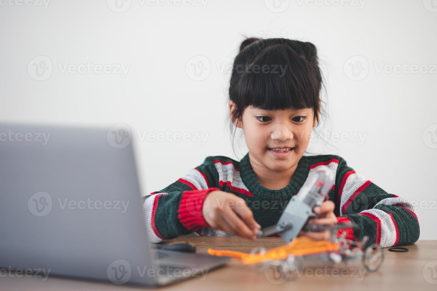 Inventive kid constructing robot cars at home photo