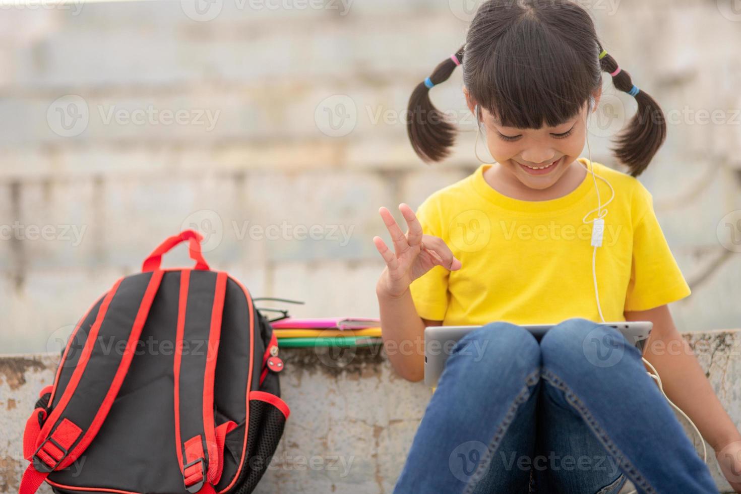 Asian little girl taking class on line and happy photo