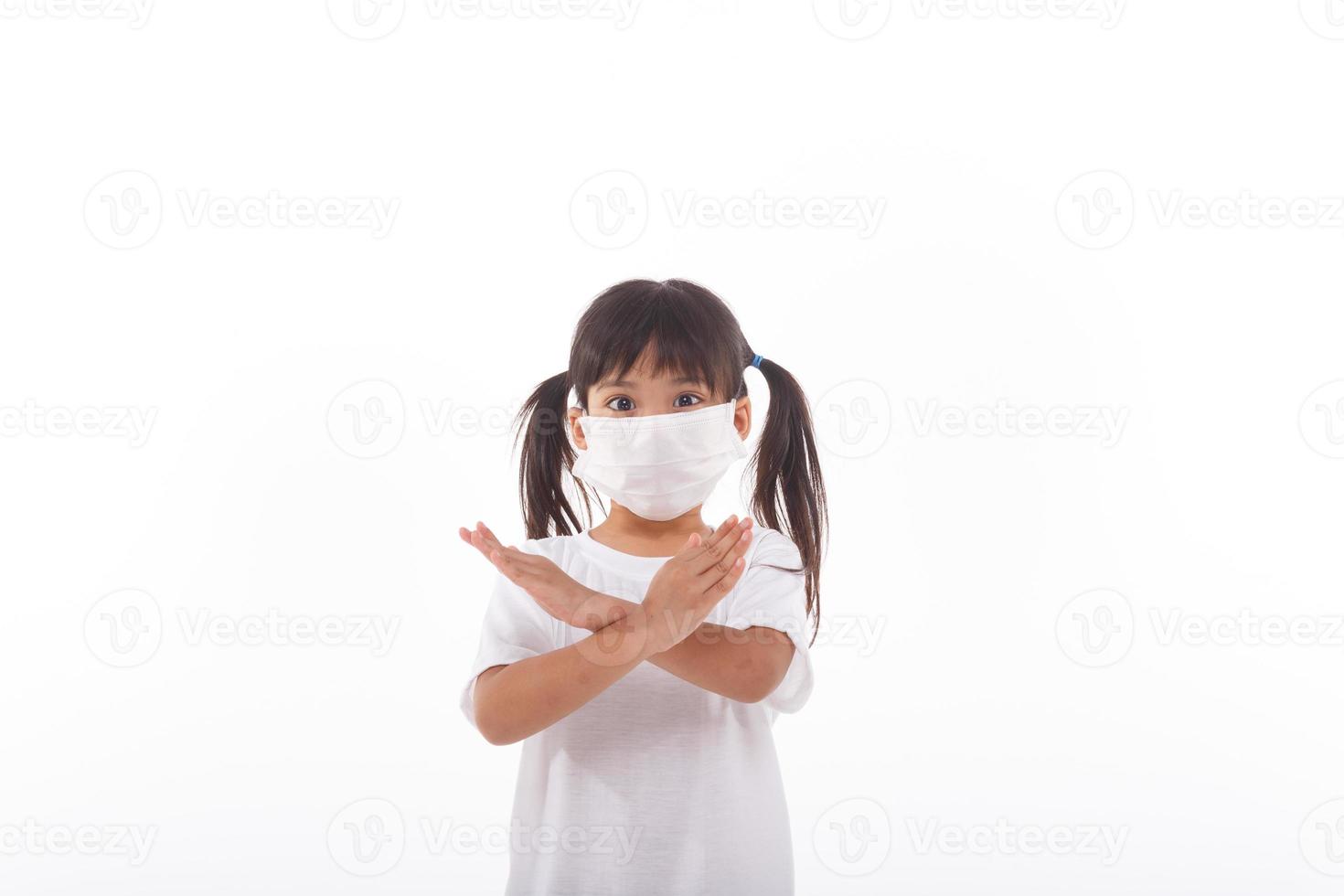 concepto de coronavirus y contaminación del aire pm2.5. niña con máscara para proteger pm2.5 y mostrar el gesto de detener las manos para detener el brote del virus de la corona. coronavirus de wuhan y síntomas del virus epidémico. foto