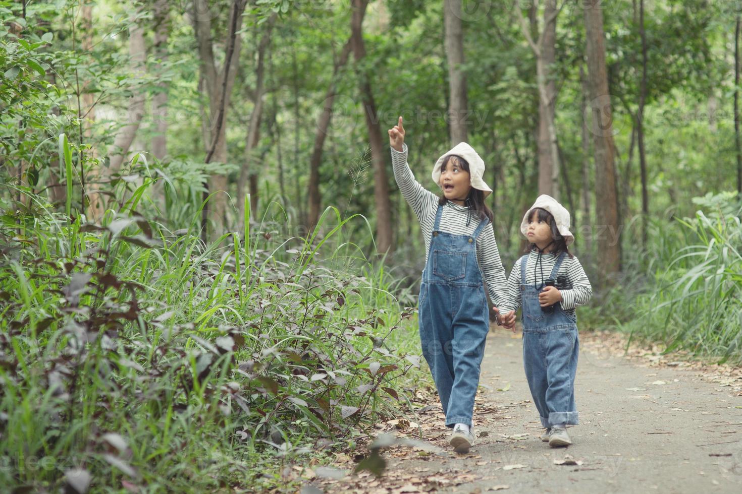 los niños se dirigen al campamento familiar en el paseo por el bosque a lo largo de la ruta turística. camino de acampada concepto de vacaciones de viaje familiar. foto