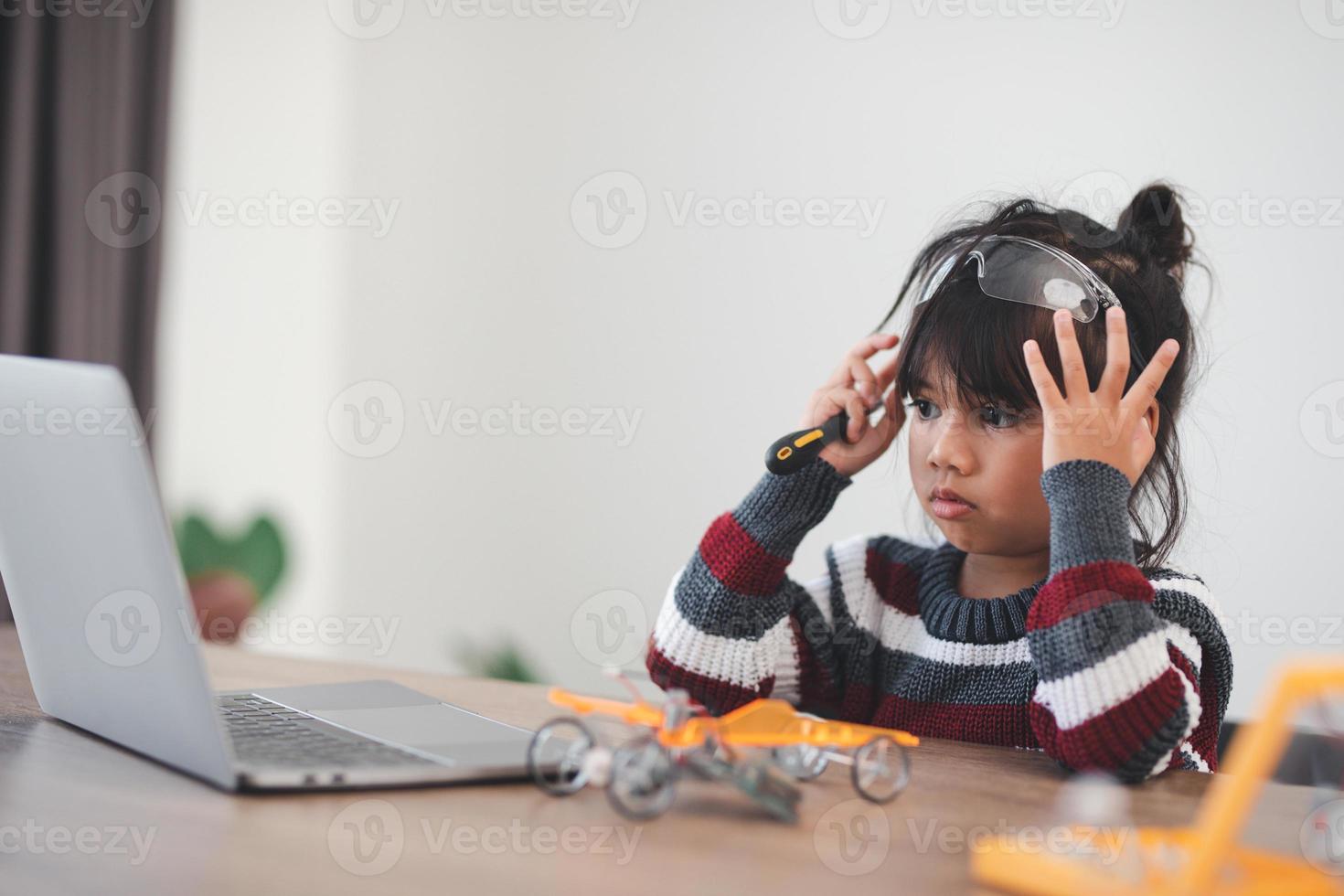 Inventive kid constructing robot cars at home photo