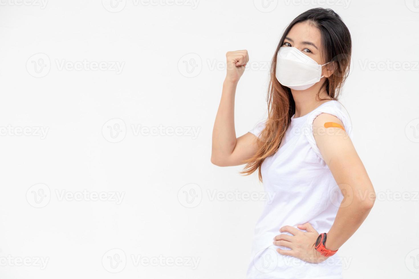 Asian Women Show Bandage On Arm. Happy Asian Woman Feels Good After Received Vaccine On White Background. photo