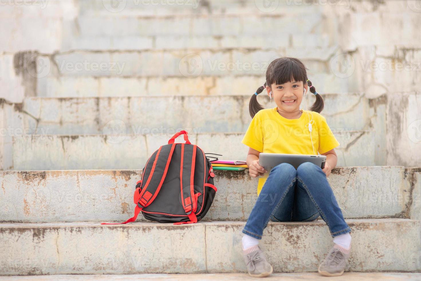 Asian little girl taking class on line and happy photo