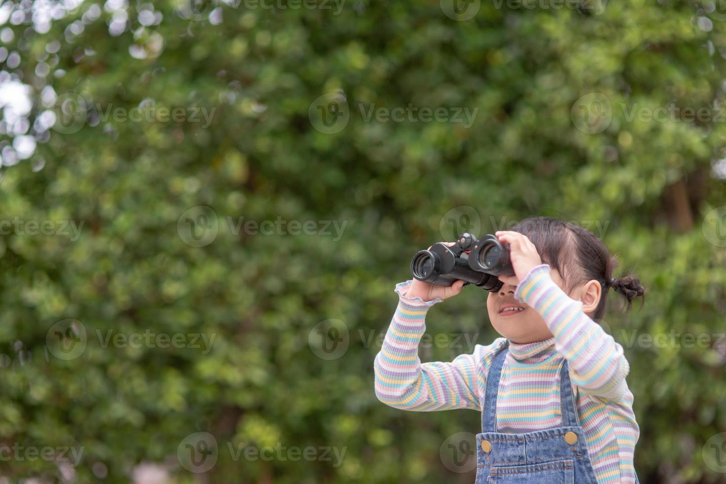 Happy kid looking ahead. Smiling child with the spyglass. Travel and adventure concept. Freedom, vacation photo