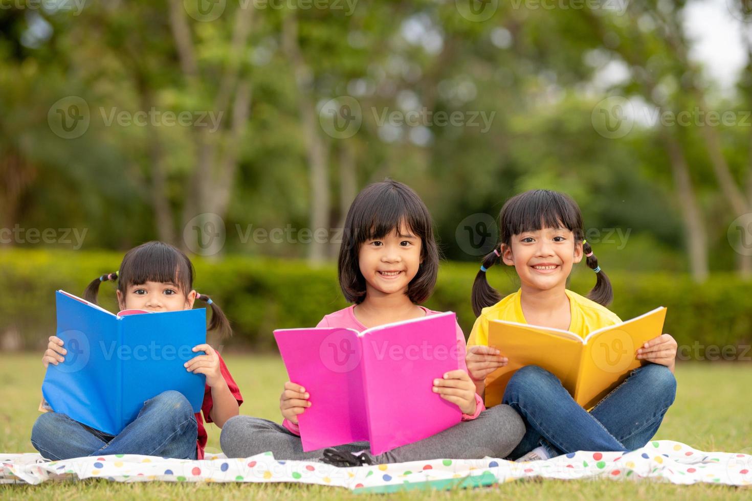 Three kids reading in the park. photo