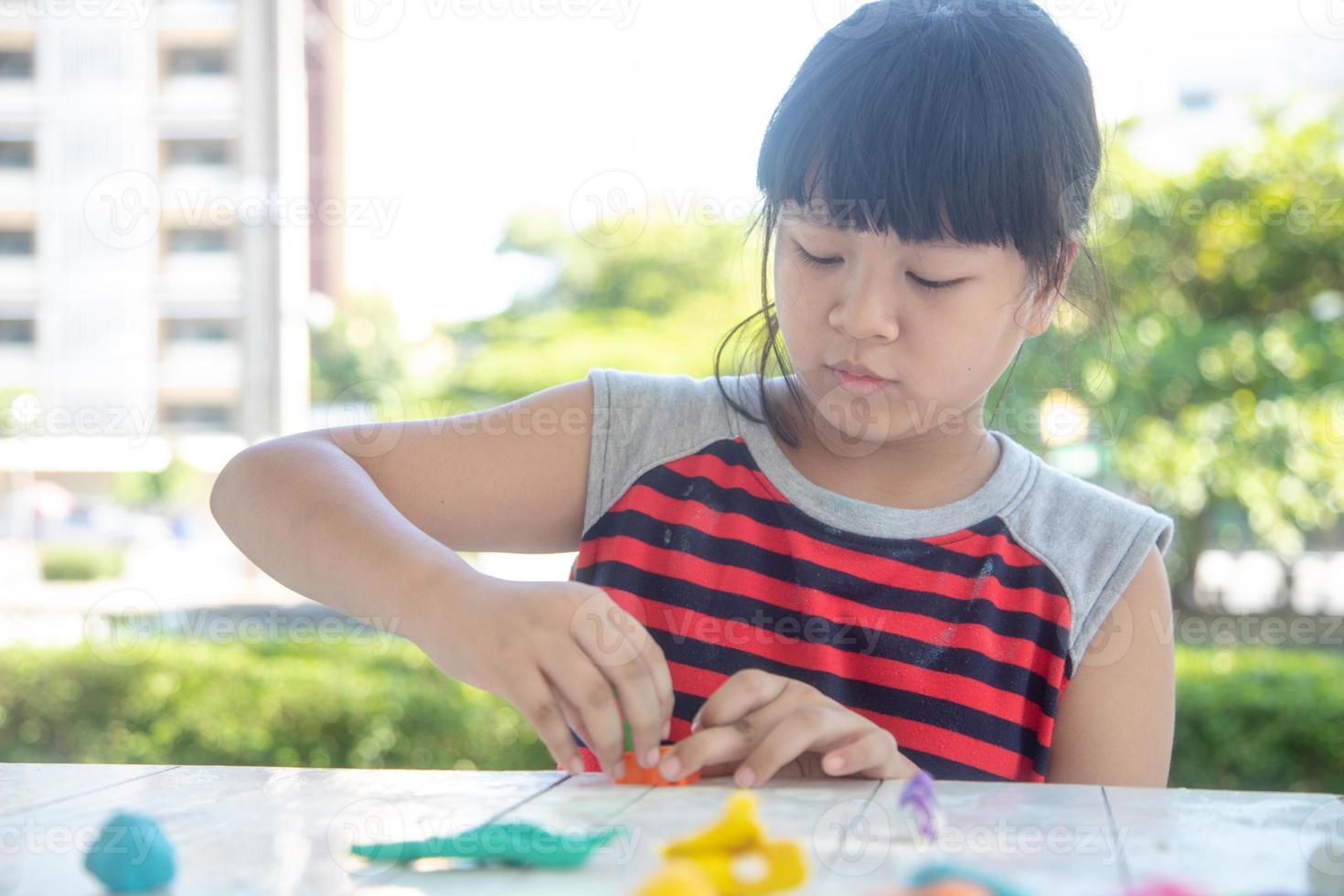 los niños asiáticos juegan con formas de moldeo de arcilla, aprendiendo a través del juego foto