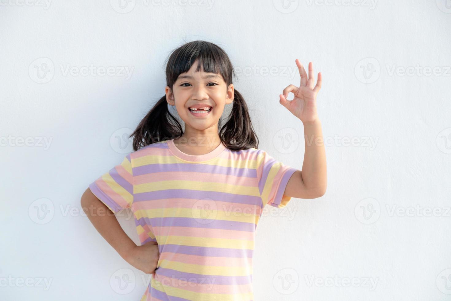 Portrait of a cute little girl kid showing okay gesture photo