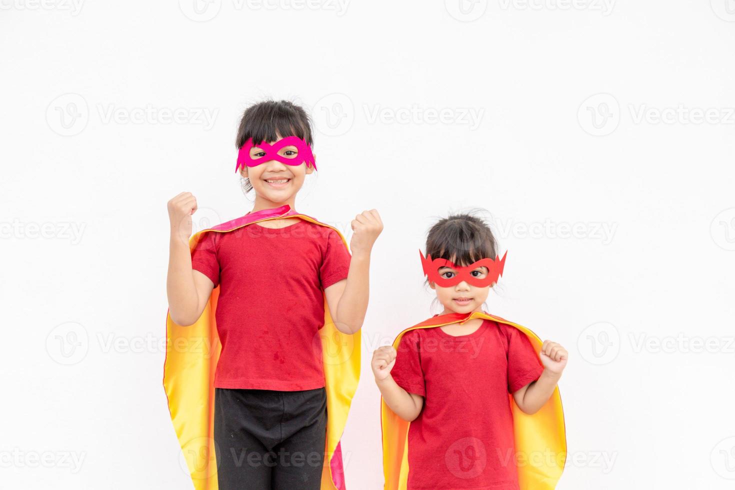 dos niñas en un traje de superhéroe sobre fondo blanco foto