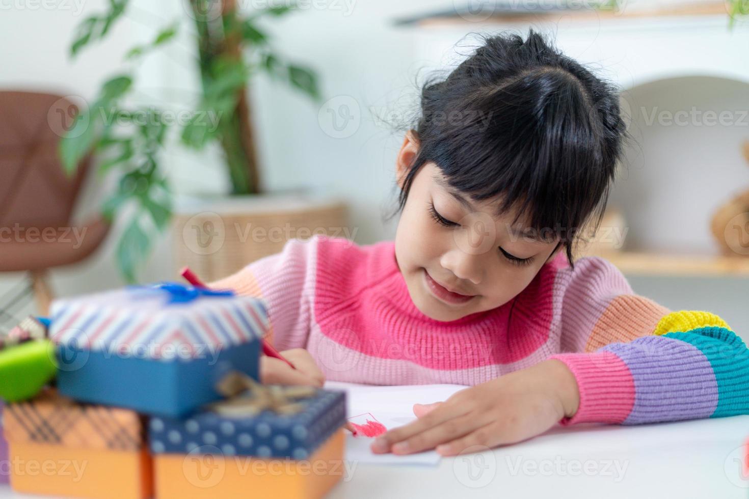 Happy Holidays. Asian little children make cards, gifts, and decorations for the holiday. Cute kids are engaged in creativity. photo