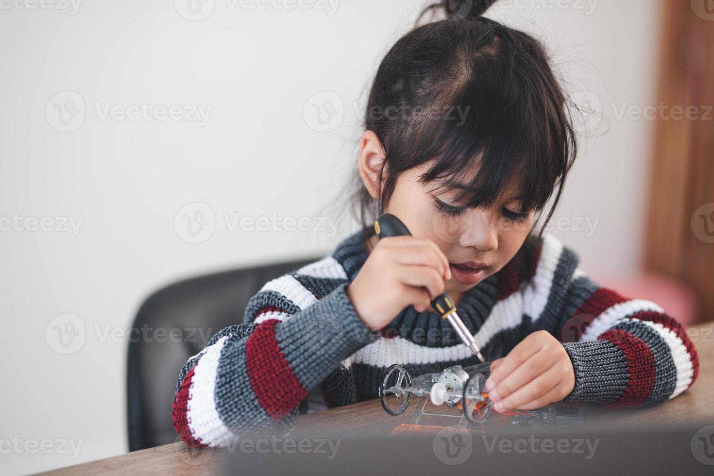 Inventive kid constructing robot cars at home photo