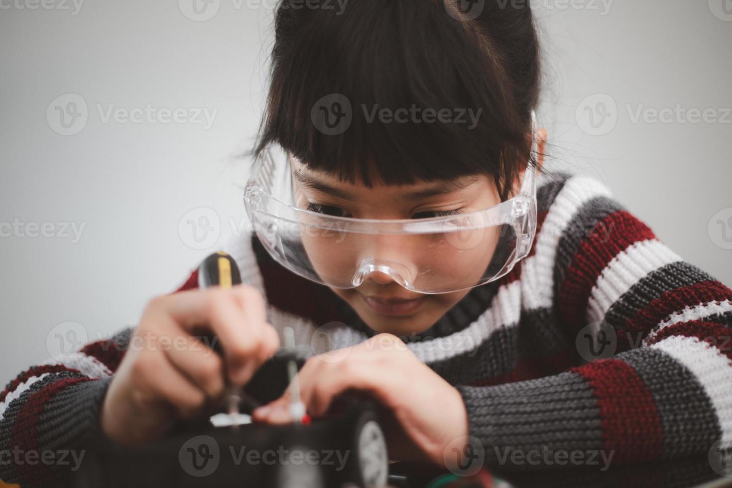 Inventive kid constructing robot cars at home photo
