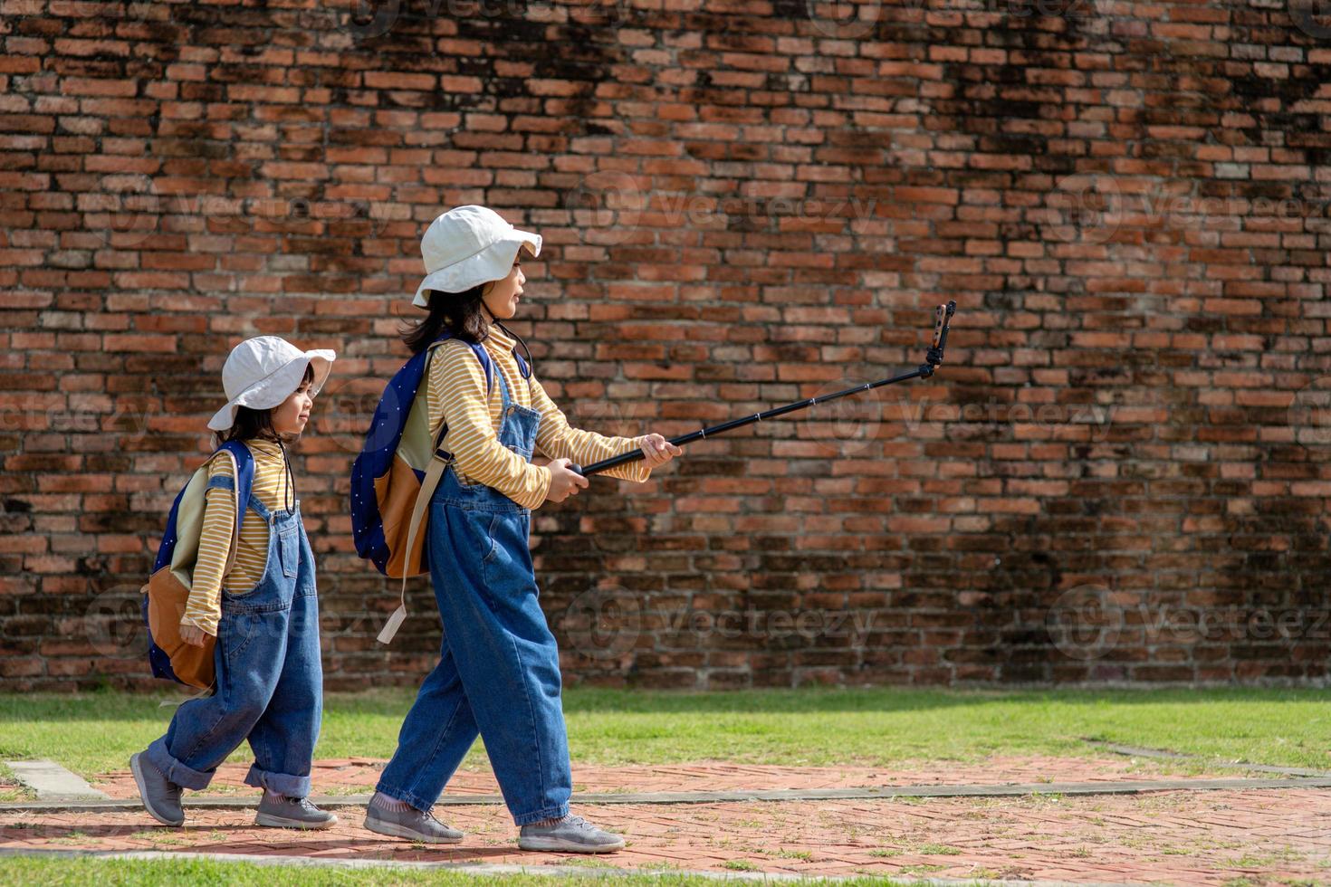 Two Asian children girls are bloggers. Broadcast on the Internet. Record vlog and blog subscribers. Record video lessons for Internet. Use camera with tripod. photo