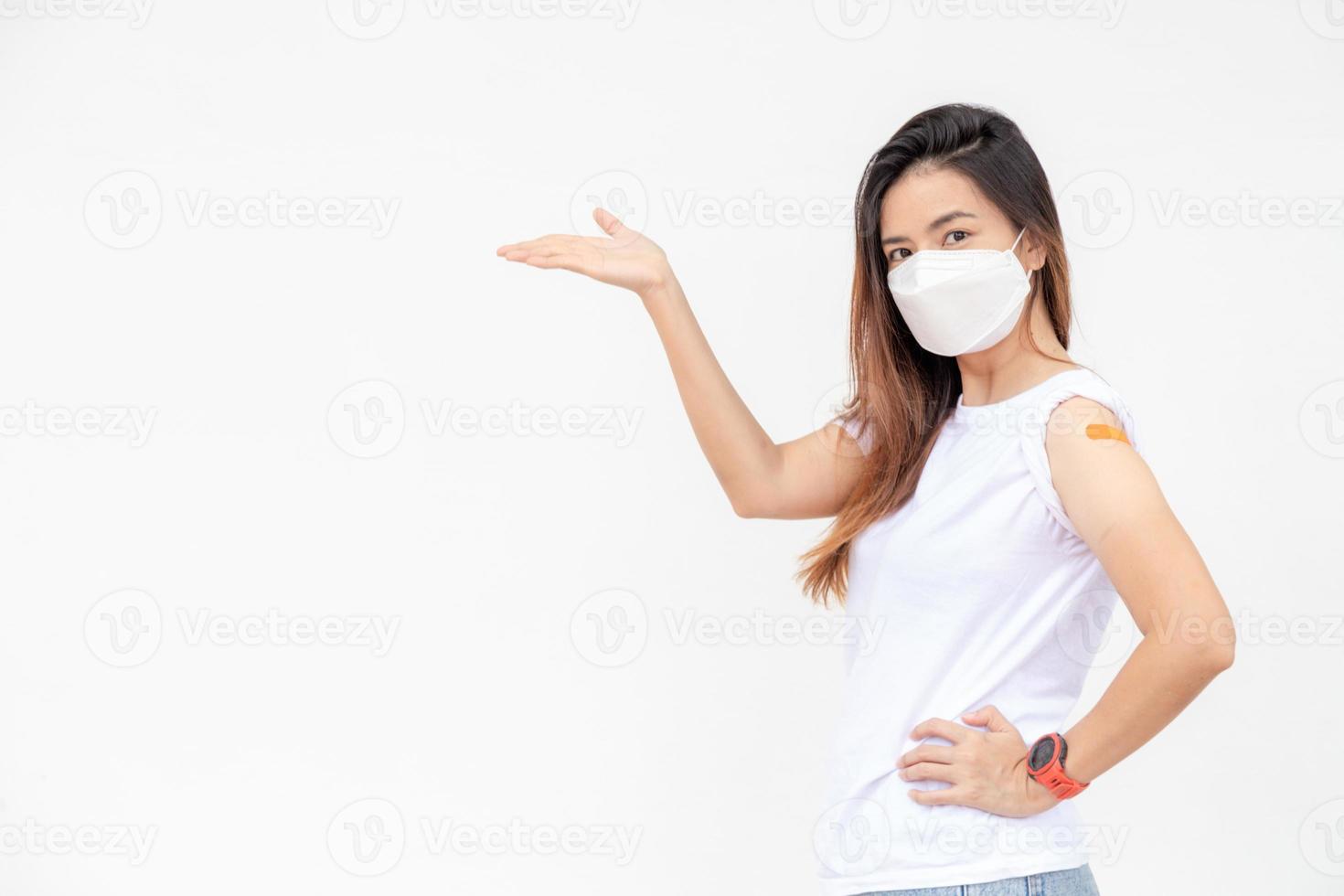 Asian Women Show Bandage On Arm. Happy Asian Woman Feels Good After Received Vaccine On White Background. photo