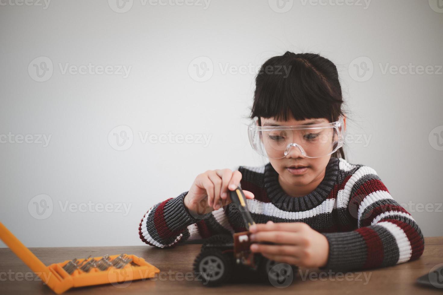 Inventive kid constructing robot cars at home photo