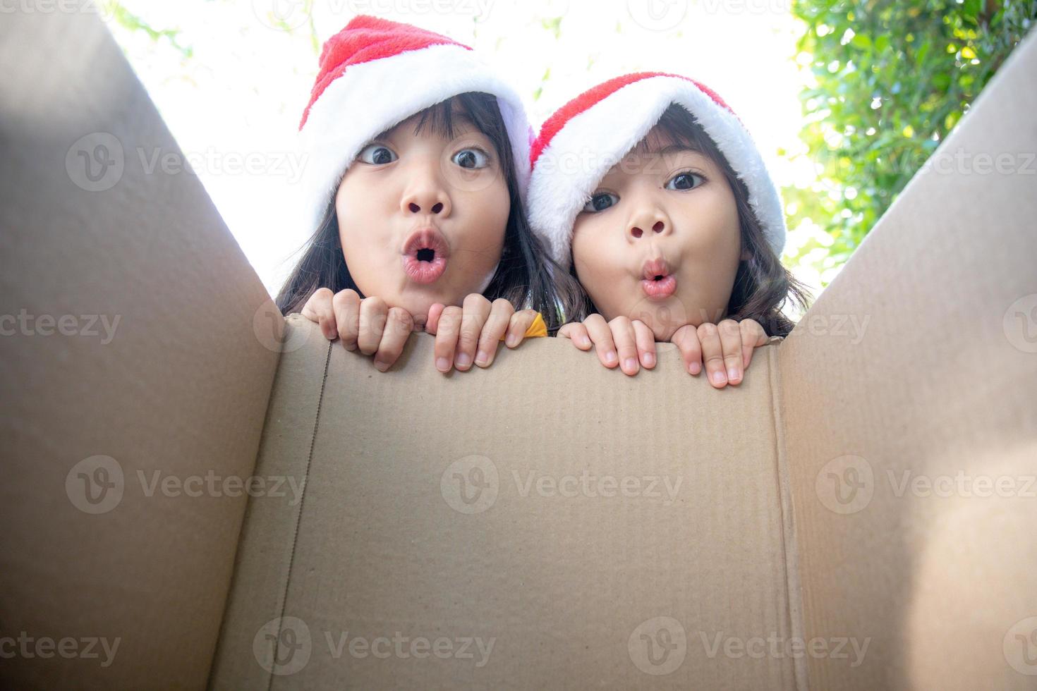 Surprised children unpack Christmas gift box photo