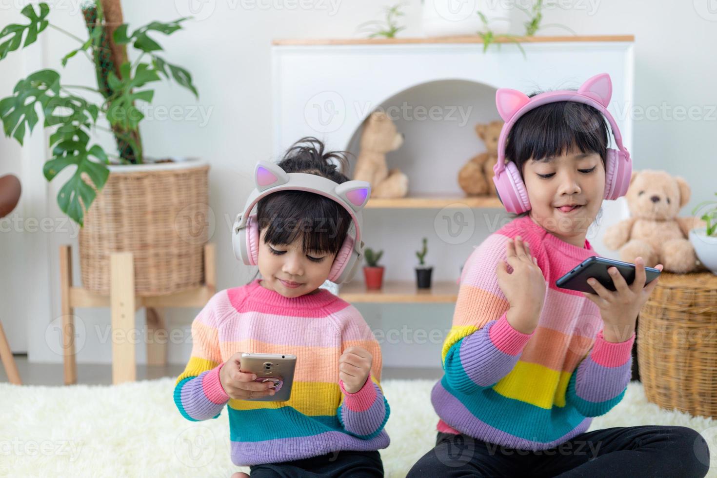 Little sibling girls listening music with headset happy together photo