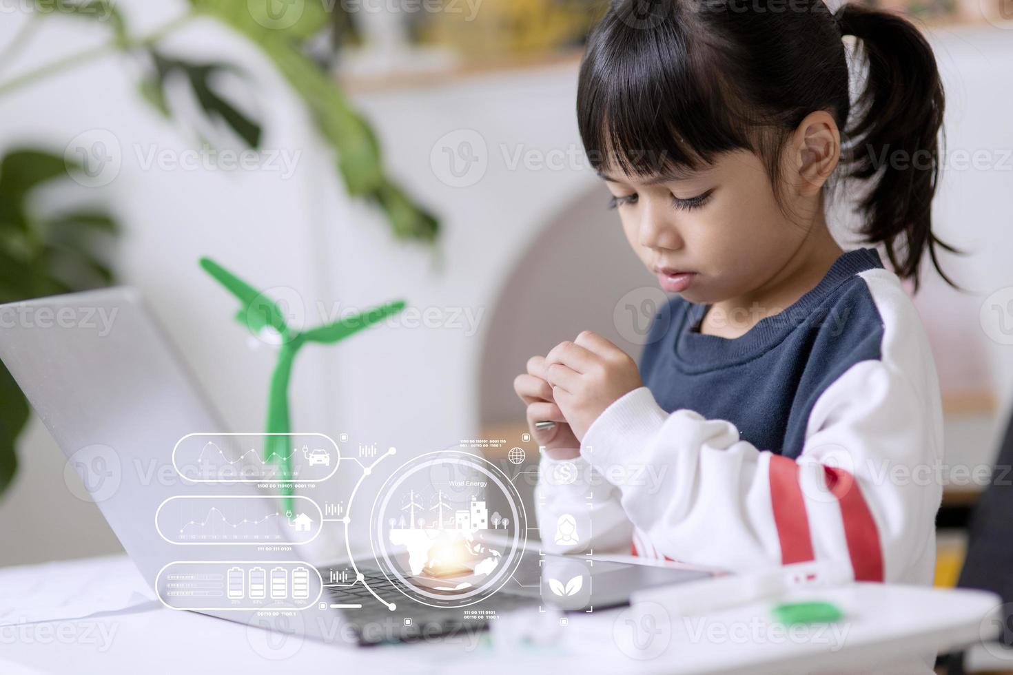 renewable energy, science, and technology concept - happy children with laptop computers, wind energy hologram,s and wind turbine models and icons. photo