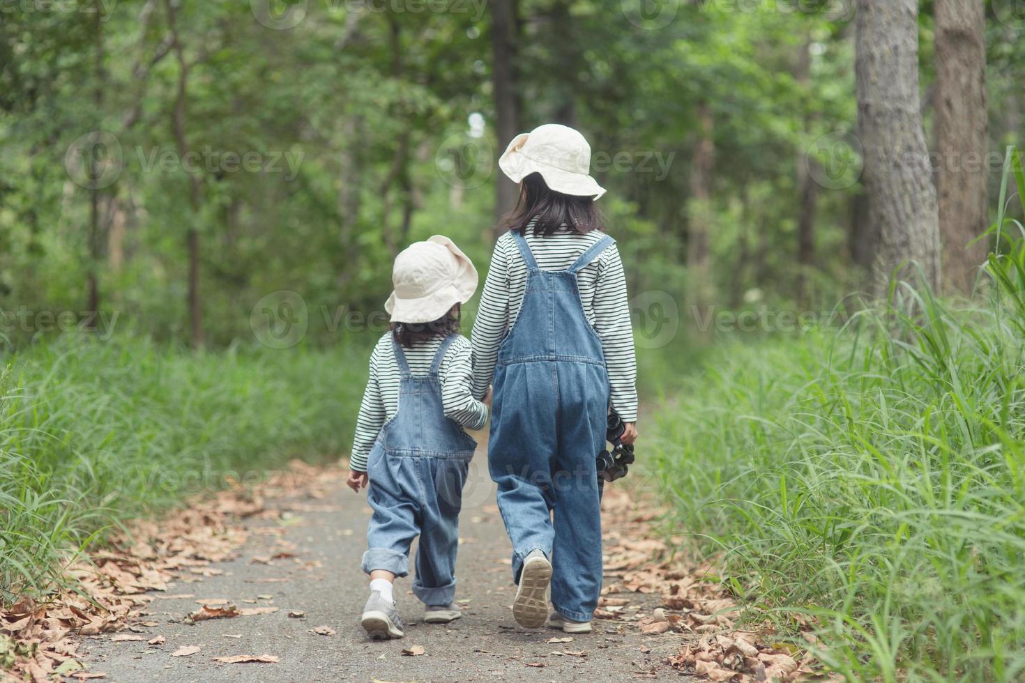 Children are heading to the family campsite in the forest Walk along the tourist route. Camping road. Family travel vacation concept. photo