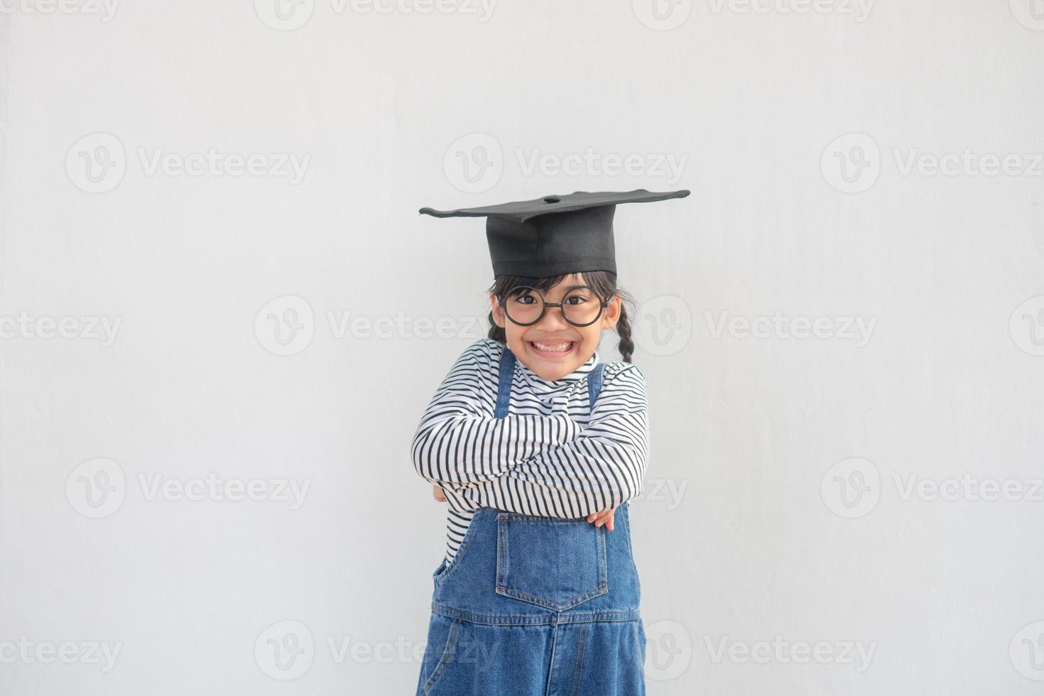 Happy Asian school kid graduate in graduation cap photo