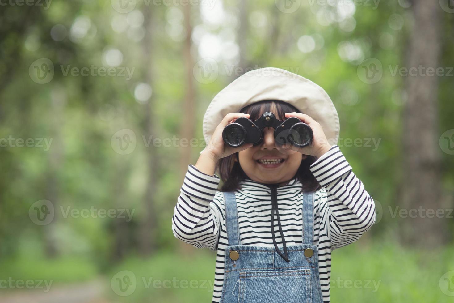 Happy kid looking ahead. Smiling child with the binoculars. Travel and adventure concept. Freedom, vacation photo