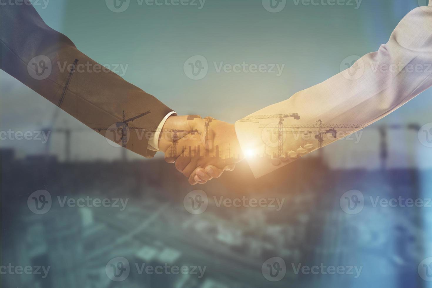 Businessmen shaking hands on city background. Double exposure. Partnership concept photo