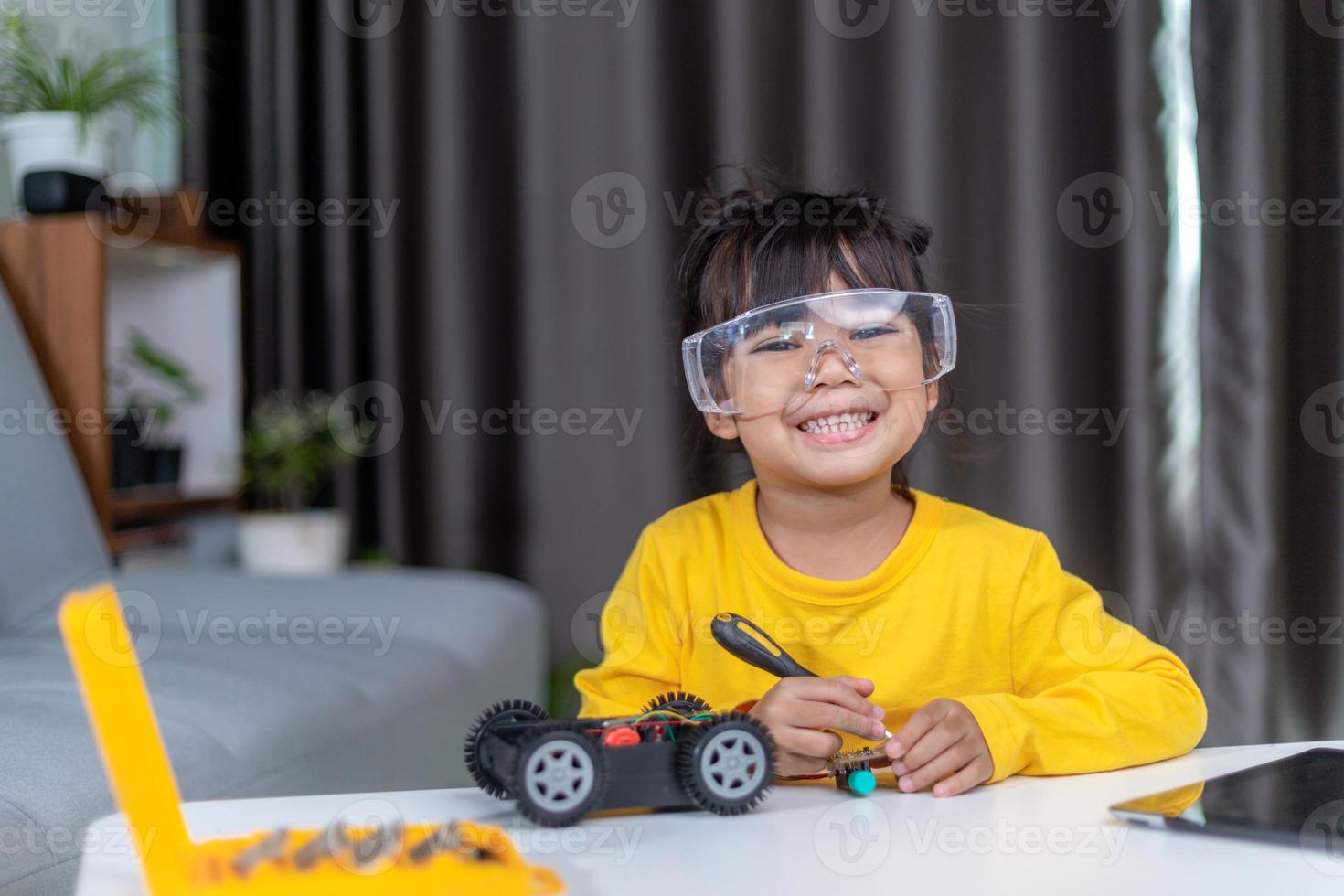 Inventive kid constructing robot cars at home photo