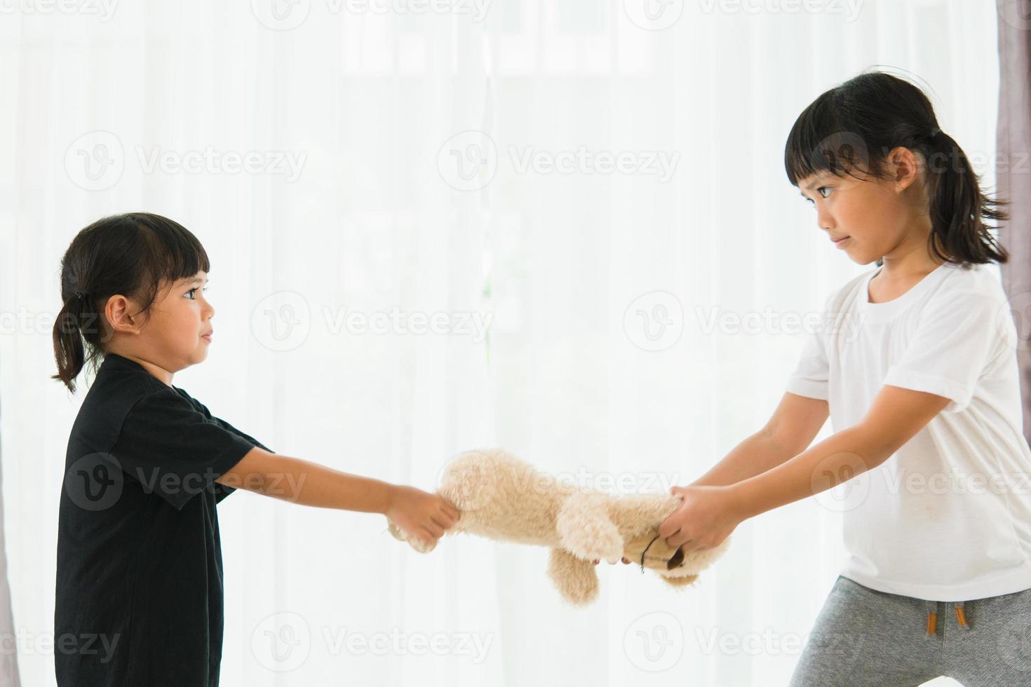 dos niñas peleando por un oso foto