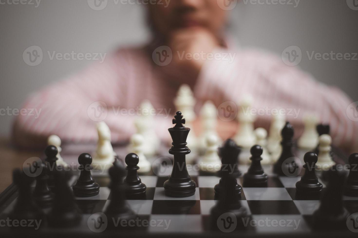 little girl playing a game of chess on a chessboard. photo