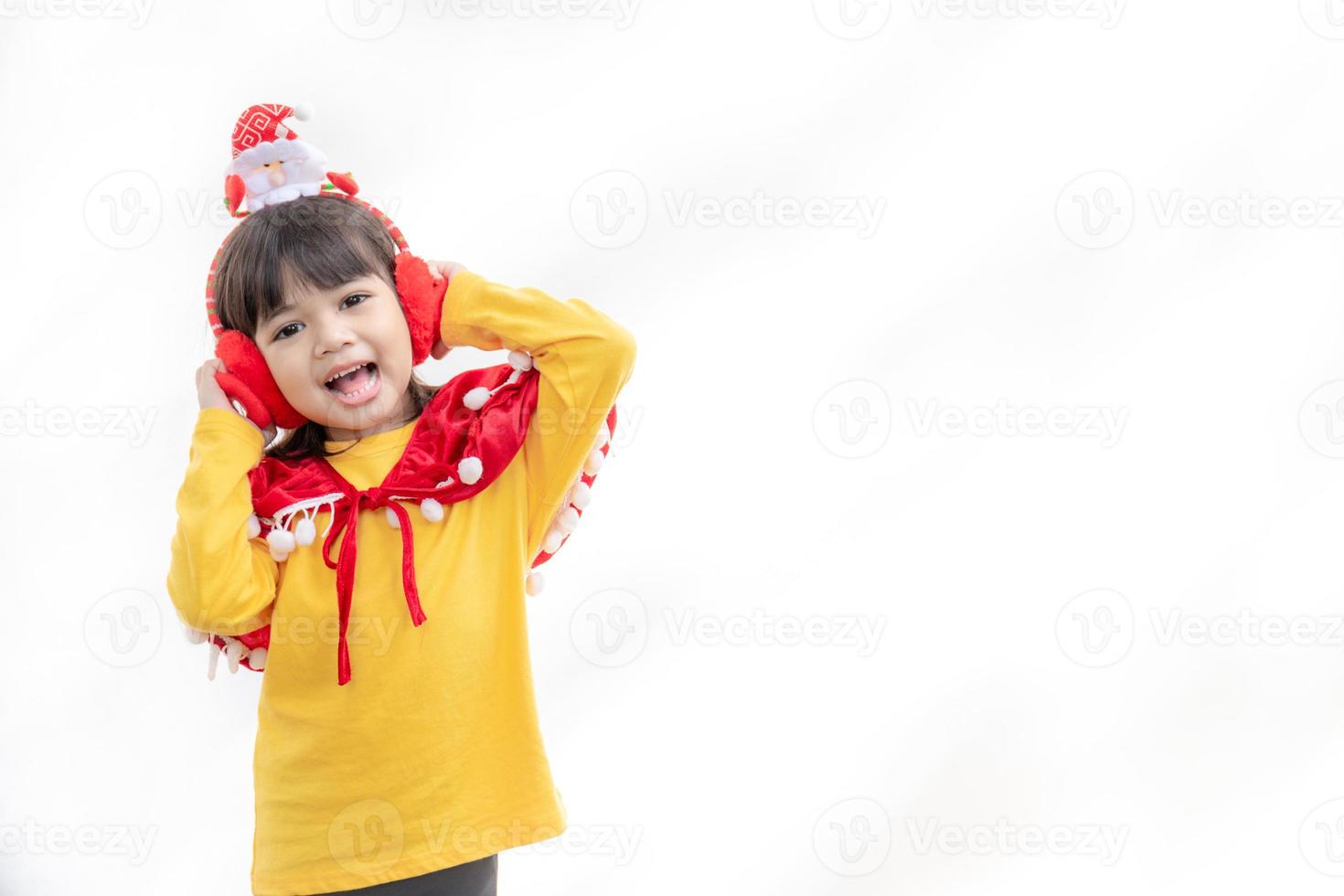 Asian little girl in red santa hat on white background. photo