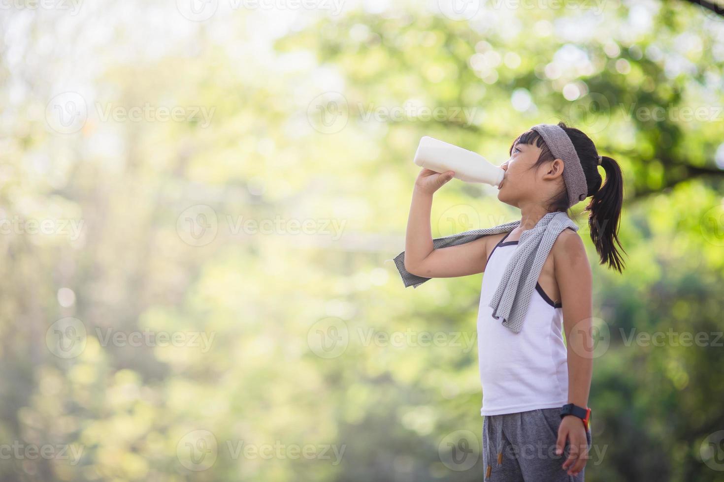 Cute asian little child girl is drinking a milk, soft focus photo