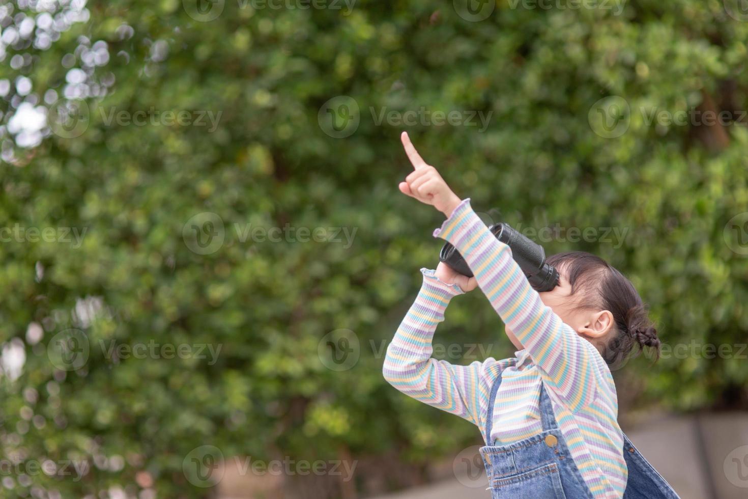 Happy kid looking ahead. Smiling child with the spyglass. Travel and adventure concept. Freedom, vacation photo