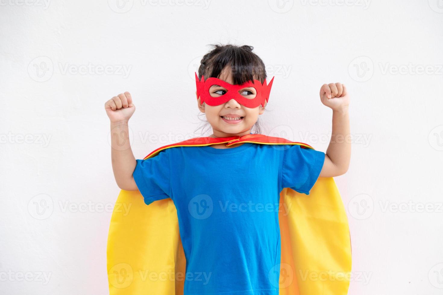 Little child girl plays superhero. Child on the white background. Girl power concept photo