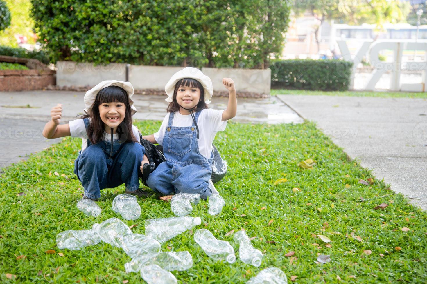 Two Asian Little girl is separate trash to recycle photo