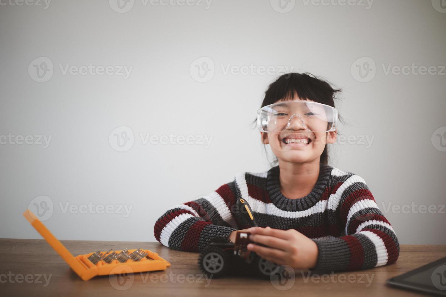 Inventive kid constructing robot cars at home photo