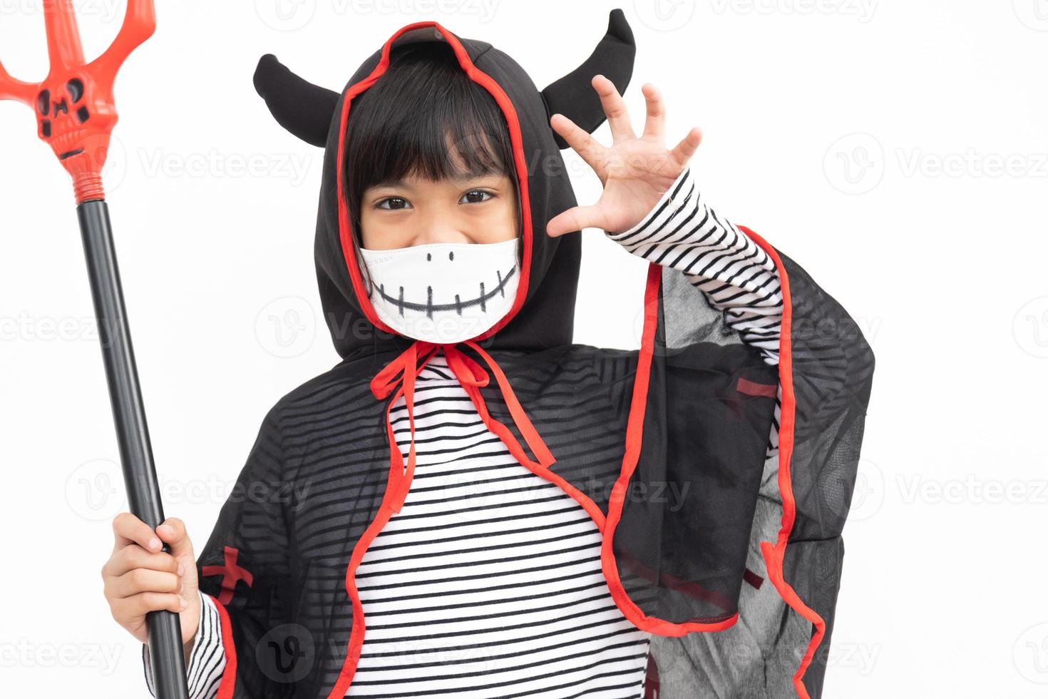 Asian little girl in a Halloween costume in a medical mask . Halloween with safety measures from Covid-19 photo