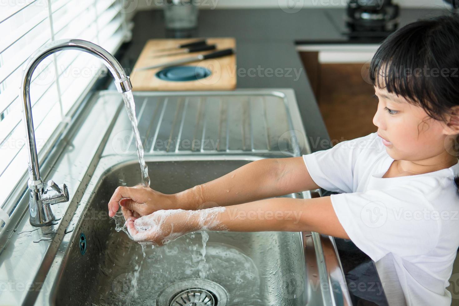 Child washing hand with soap photo