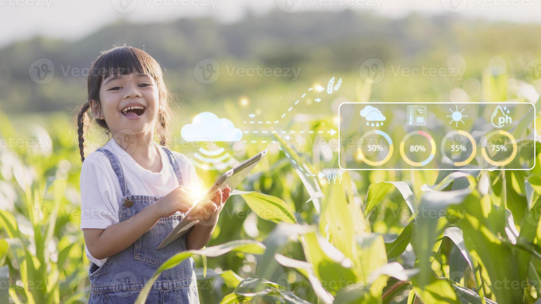 The little girl uses a tablet to analyze the growth of plants in the agricultural plot and visual icon., the agricultural technology concept. smart farming learning Concept photo