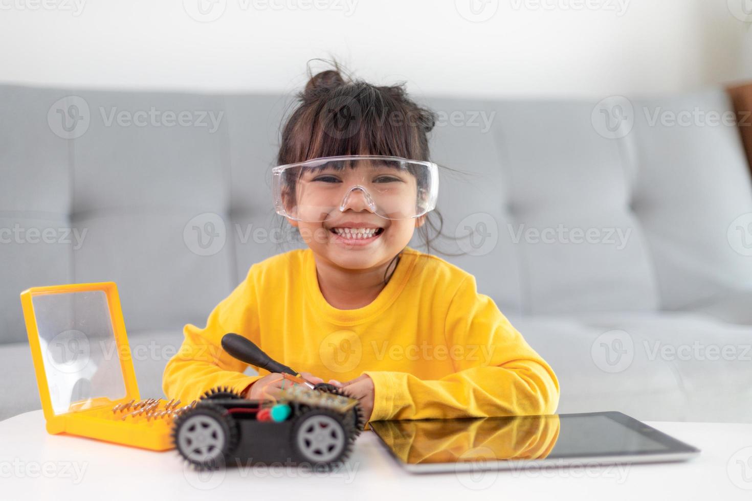 Inventive kid constructing robot cars at home photo