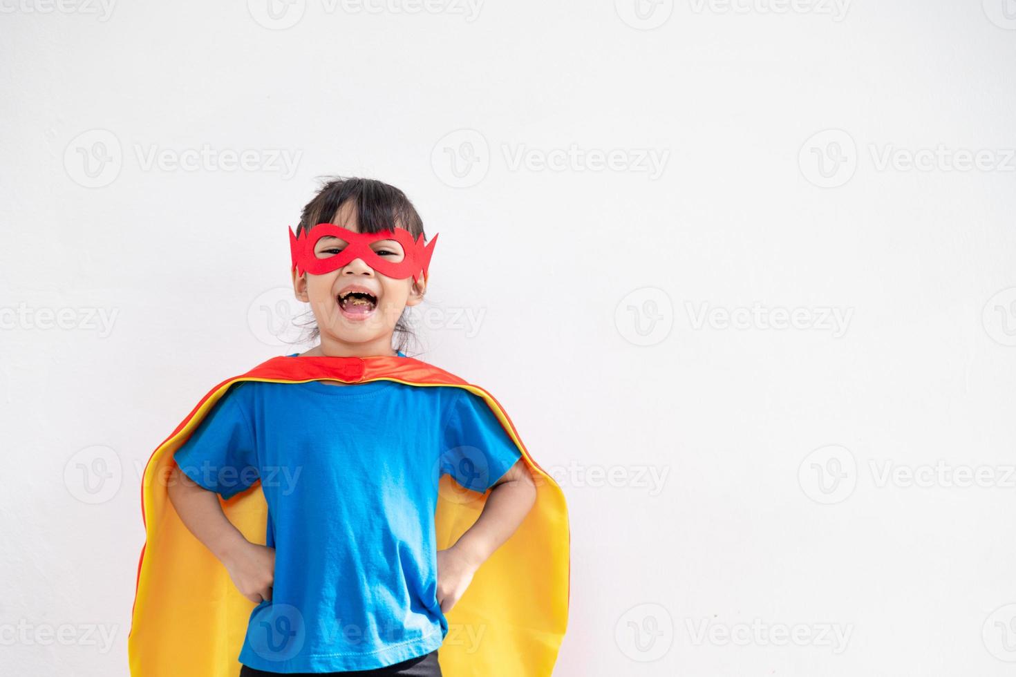 Niña divertida jugando superhéroe de poder sobre fondo blanco. concepto de superhéroe. foto