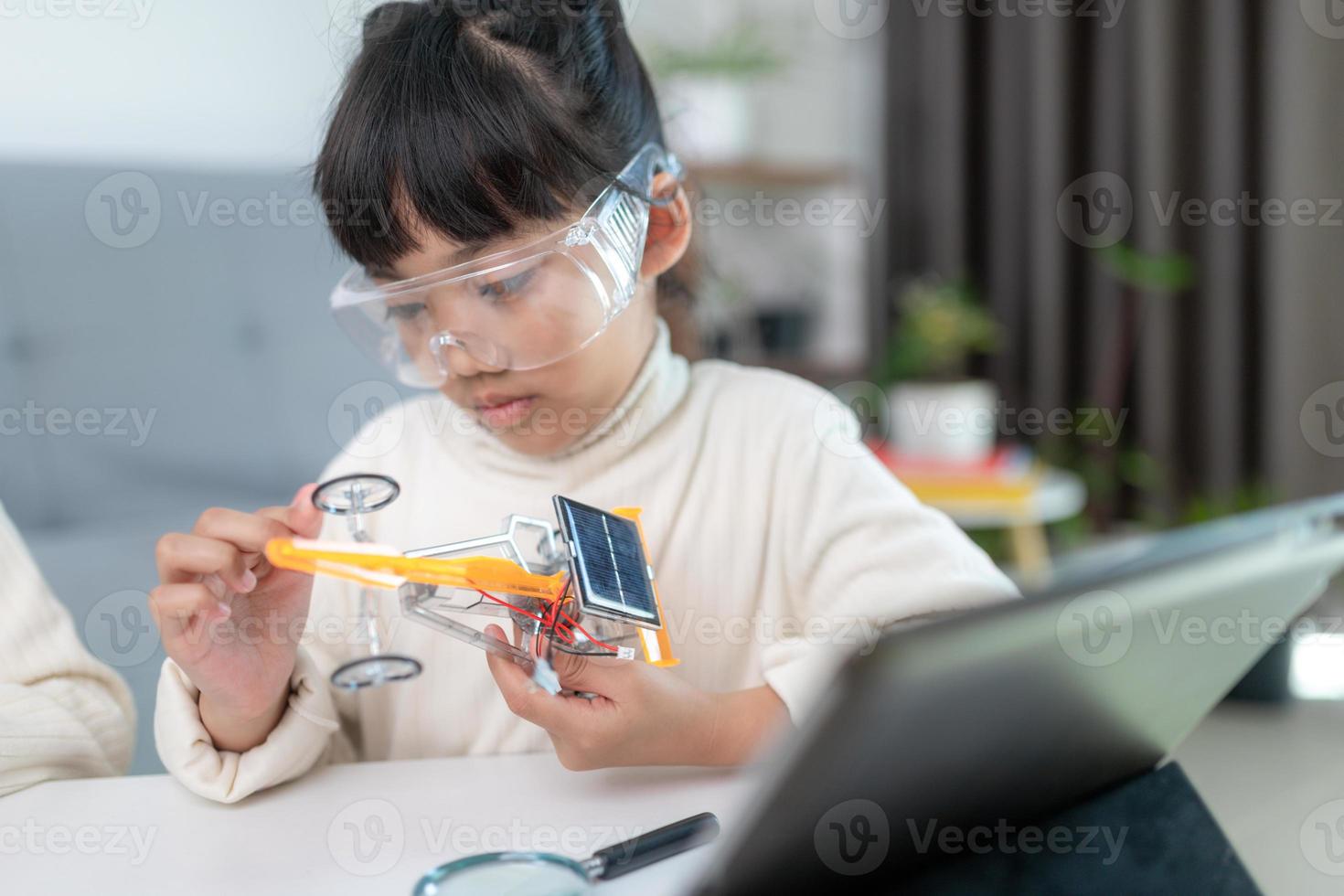 Inventive kid constructing robot cars at home photo
