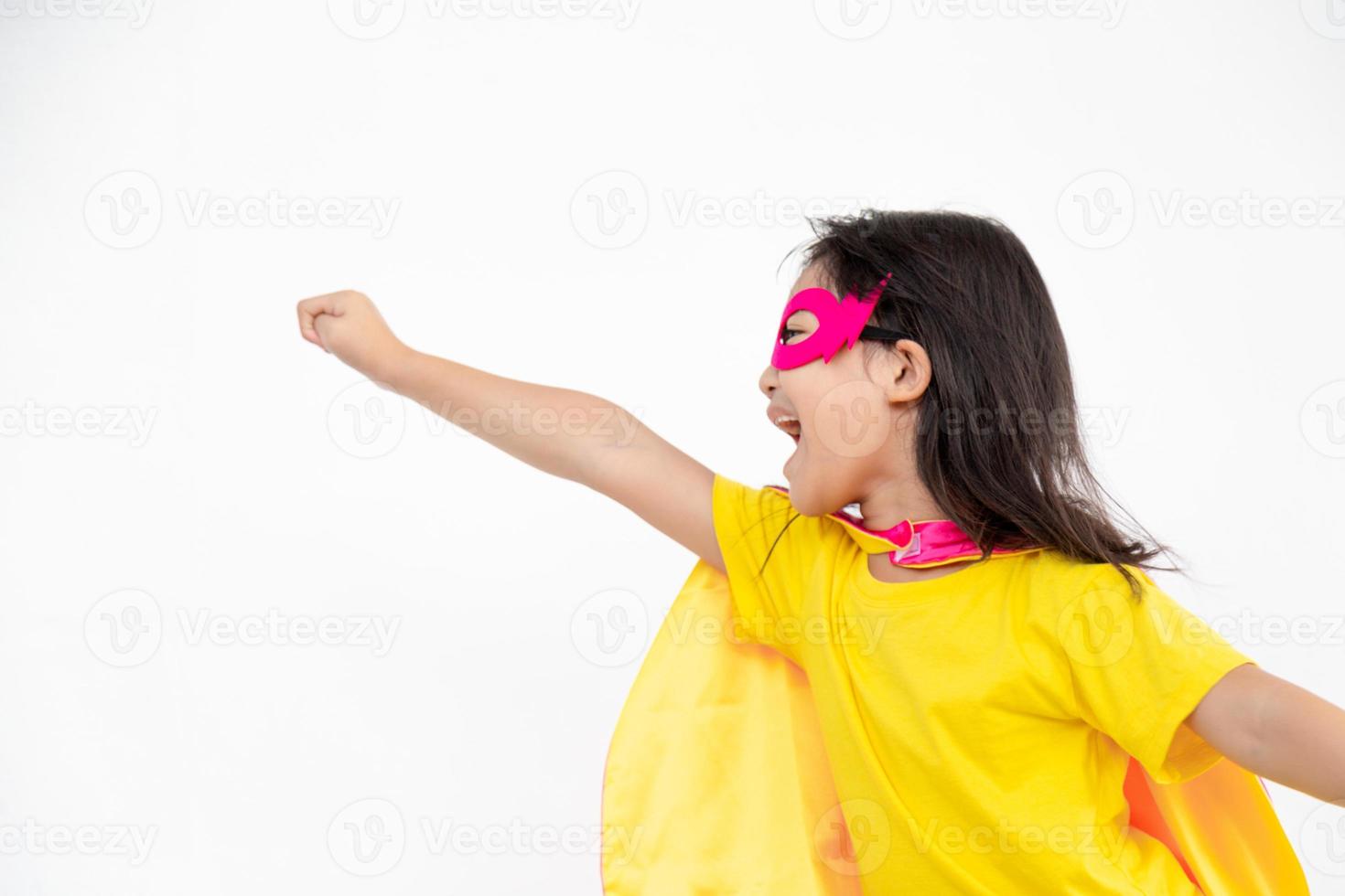 Funny little girl playing power super hero over white background. Superhero concept. photo