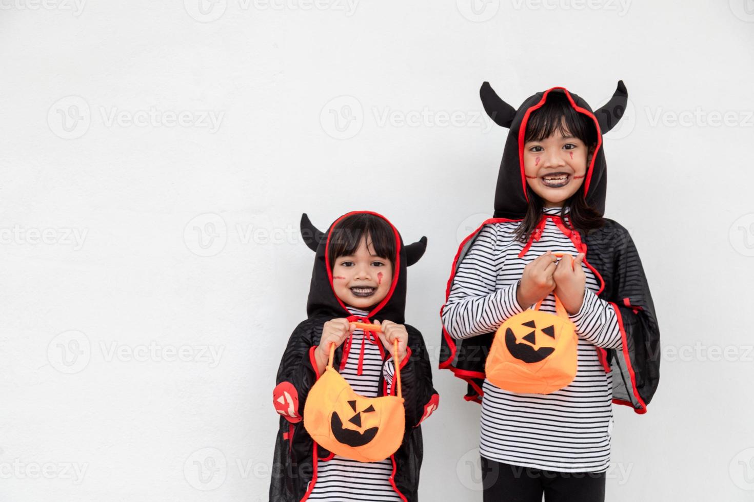 happy Halloween two children in Halloween costumes and with pumpkins on white background photo