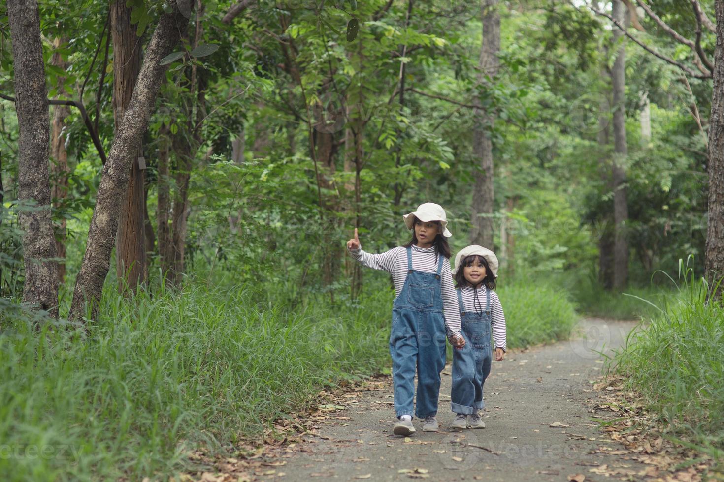 Children are heading to the family campsite in the forest Walk along the tourist route. Camping road. Family travel vacation concept. photo