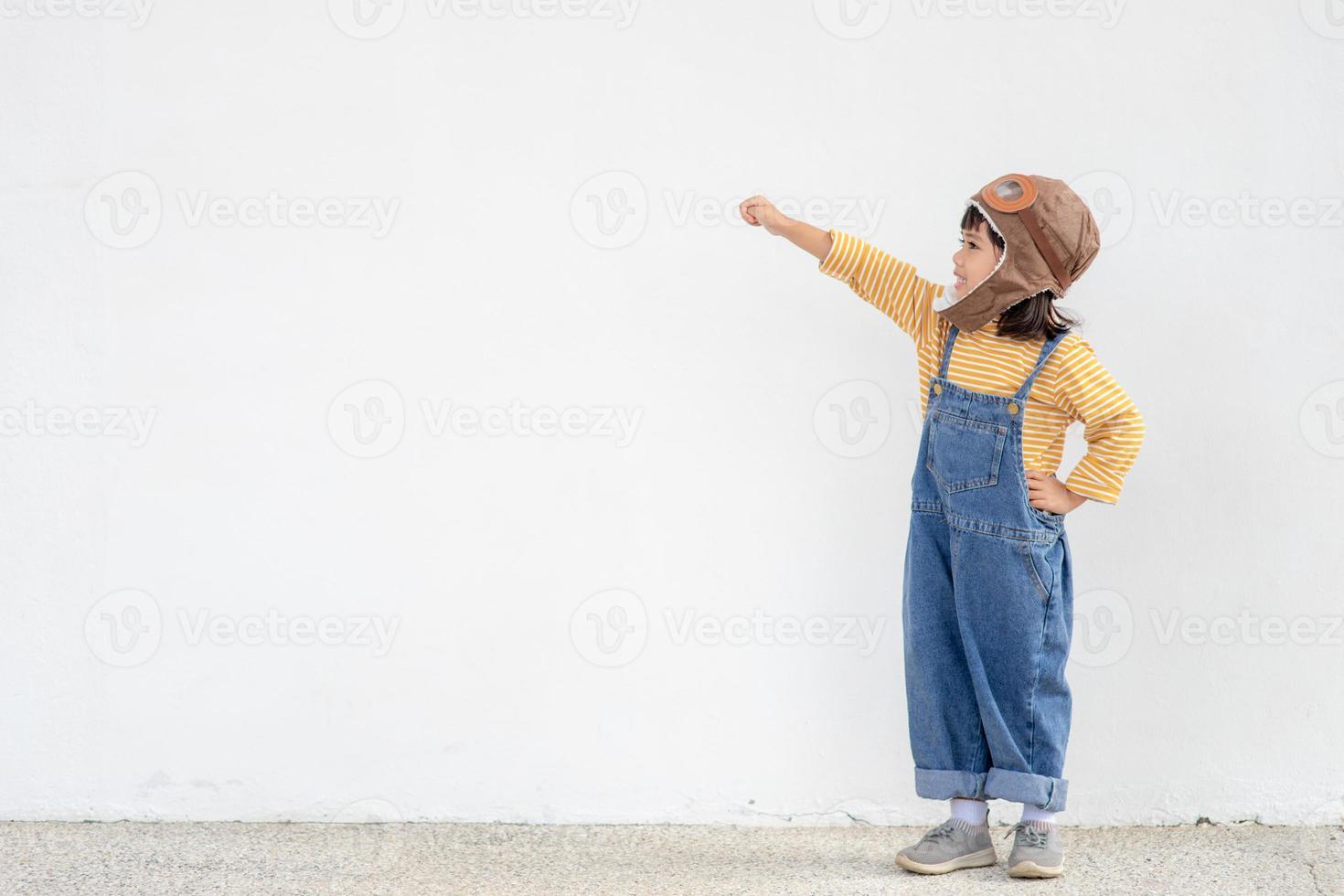 A little child girl in an astronaut costume is playing and dreaming of becoming a spaceman. on white background photo