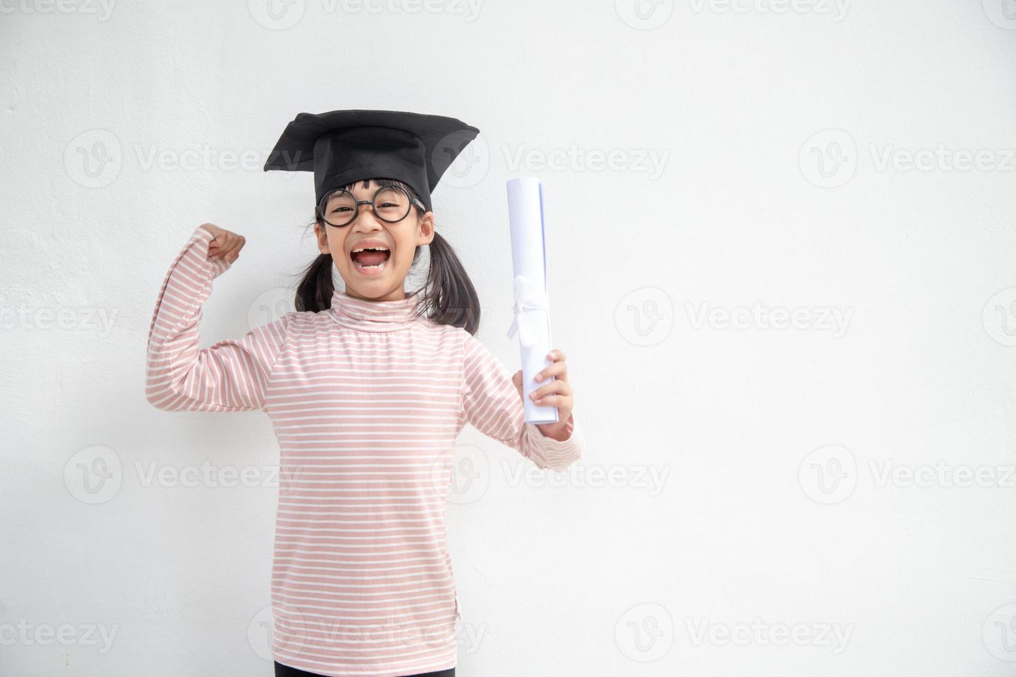 feliz niño de la escuela asiática graduado en gorra de graduación foto